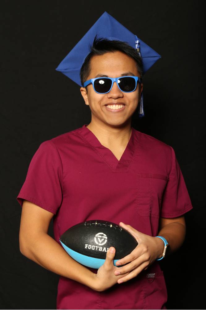 gvsu grad holding football with sunglasses